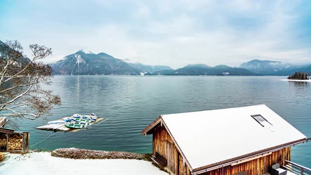 船屋和划艇在湖岸与山脉的背景延时视频素材