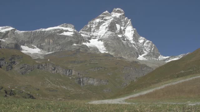 徒步旅行者指的是马特洪峰或马特洪峰或塞尔文山，以及瑞士阿尔卑斯山和里费尔湖。欧洲瑞士瓦莱州泽马特市的户外活动。视频素材