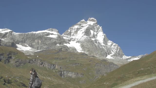 徒步旅行者指的是马特洪峰或马特洪峰或塞尔文山，以及瑞士阿尔卑斯山和里费尔湖。欧洲瑞士瓦莱州泽马特市的户外活动。视频素材