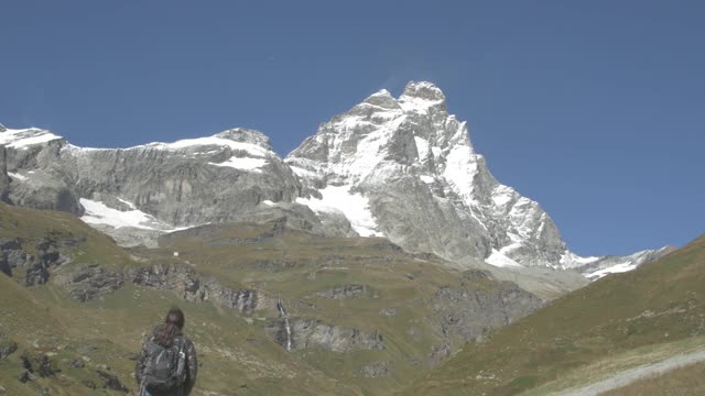 徒步旅行者指的是马特洪峰或马特洪峰或塞尔文山，以及瑞士阿尔卑斯山和里费尔湖。欧洲瑞士瓦莱州泽马特市的户外活动。视频素材