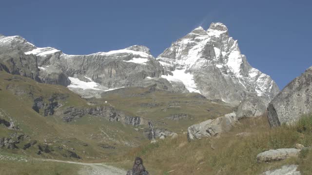 徒步旅行者指的是马特洪峰或马特洪峰或塞尔文山，以及瑞士阿尔卑斯山和里费尔湖。欧洲瑞士瓦莱州泽马特市的户外活动。视频素材