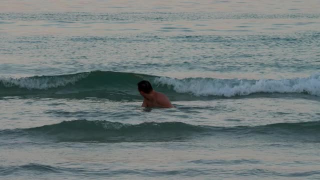 有趣的人在海滩的海水里跳视频素材