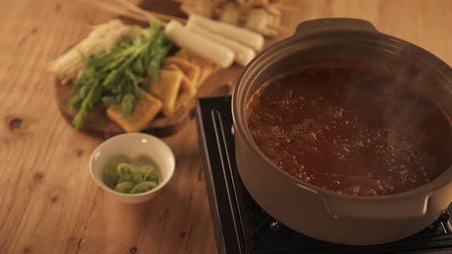 冬季食物-将鱼饼汤的食材放入煮熟的肉汤中视频素材