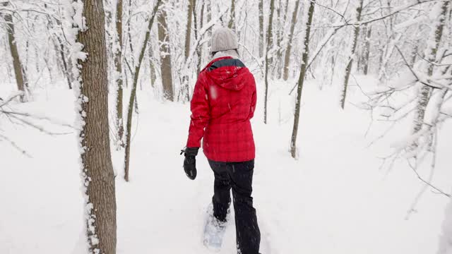 母亲和儿子在冬天雪鞋户外在暴风雪视频素材