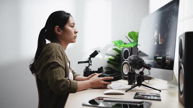 后期制作-女性视频编辑用耳机在电脑上编辑视频视频素材