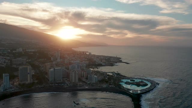 航空全景Puerto de la Cruz度假村和游泳池被海浪包围在日落，特内里费，加那利群岛，西班牙。视频素材