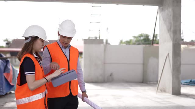 亚洲华人建筑师使用蓝图和数字板在工地上检验进展视频素材