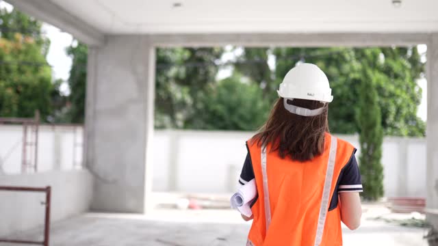 亚洲华裔女建筑师在工地上用数字平板展示建筑进展。视频素材