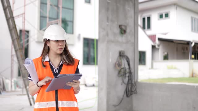 亚洲华裔女建筑师在工地上用数字平板展示建筑进展。视频素材