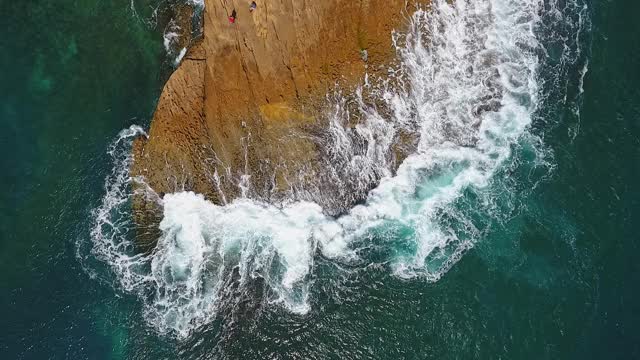 怀旧的航空视频，在缓慢的动作的海洋，波浪平稳地滚在岩石海岸的太平洋大西洋。视频素材