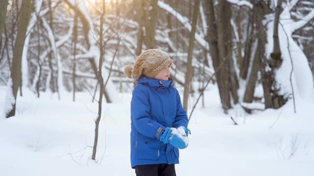 小男孩在玩新鲜的雪。打雪仗。在大雪纷飞的冬日，孩子们活跃的户外休闲活动。视频素材