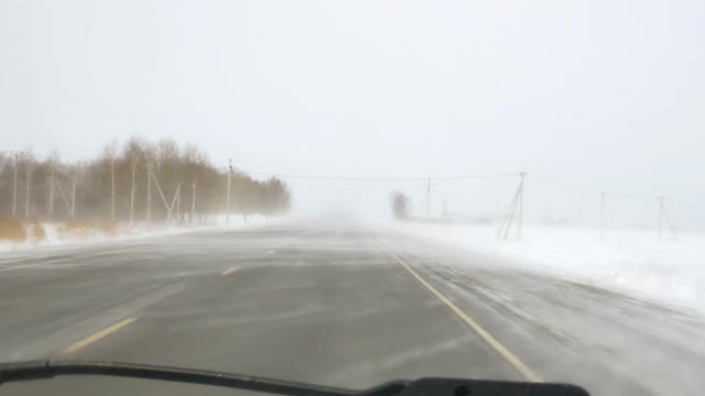 暴风雪在高速公路上从车窗向外袭来，路面结冰危险视频素材