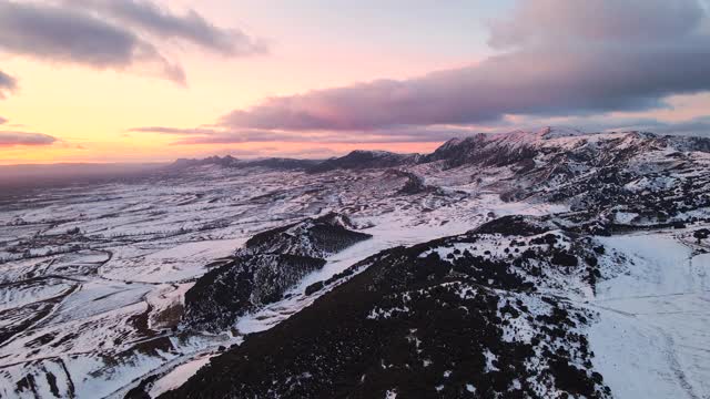 鸟瞰日落时白雪覆盖的高山。高质量4k镜头视频素材