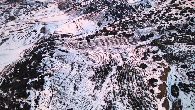 鸟瞰日落时白雪覆盖的高山。高质量4k镜头视频素材