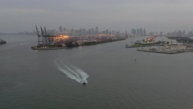 航拍海上的船只由商业码头对着天空，无人机向后飞行在城市港口在日落-迈阿密，佛罗里达视频素材