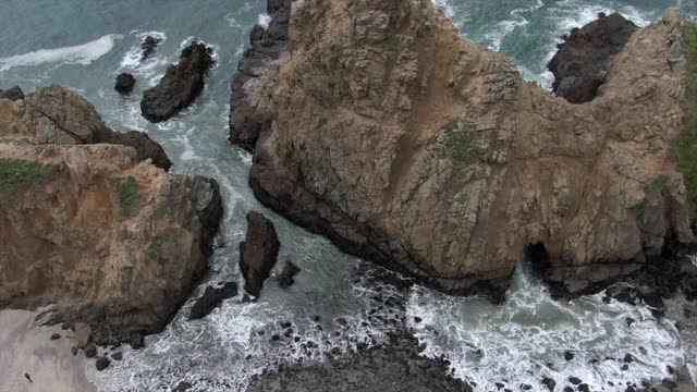 空中摇摄著名的锁眼拱门在海上对天空，无人机上升在海滩海岸-大苏尔，加利福尼亚视频素材