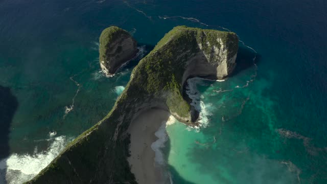 空中淘金，在陡峭的海滩悬崖上高耸入碧蓝的海水中，有旋涡的海浪和沙滩，阳光普照的海滩-努沙佩尼达&龙目岛，巴厘岛视频素材