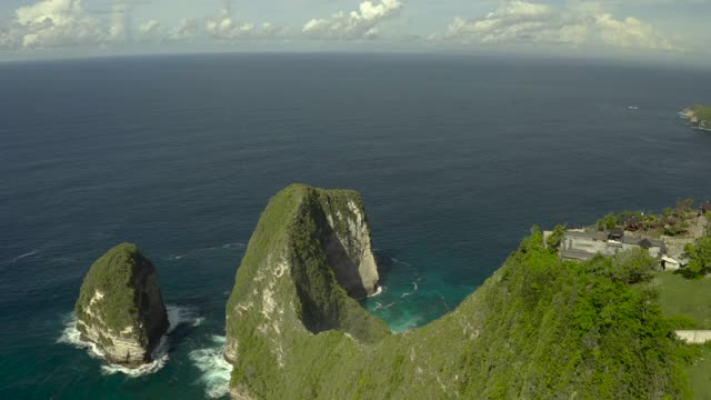 空中向前移动沿着陡峭的海滩悬崖突出到深蓝色的海水延伸到地平线-努沙佩尼达和龙目岛，巴厘岛视频素材