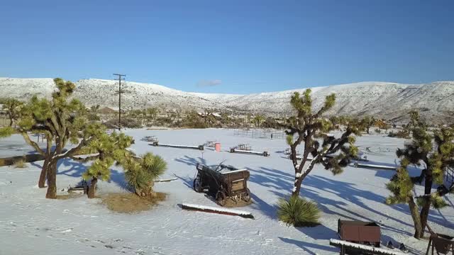 空中拍摄的雪景与山脉的天空，无人机飞向城镇在阳光明媚的一天-乔舒亚树，加利福尼亚视频素材