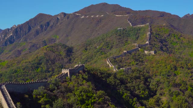 斯坦尼康镜头拍摄的中国长城，在山的一侧上升在一个开始下降。摄像头通过瞭望塔的通道，显示了从墙上的窗户看到的景色视频素材