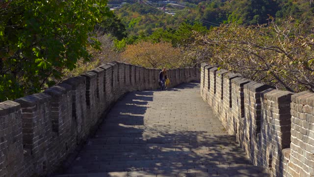 斯坦尼康镜头拍摄了一个年轻的女人和她的小儿子走上中国长城的楼梯视频素材