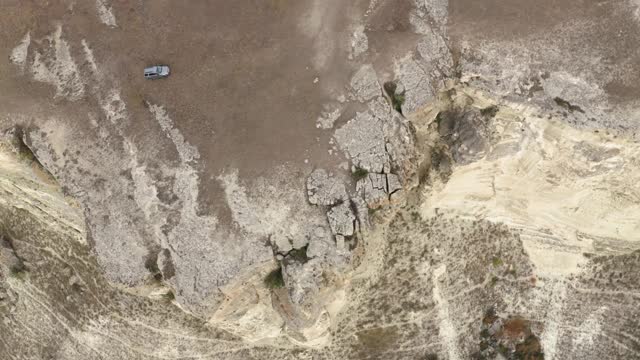 越野汽车在山区肮脏的道路上行驶。鸟瞰图旅行越野车移动在山谷之间的岩石和悬崖视频素材