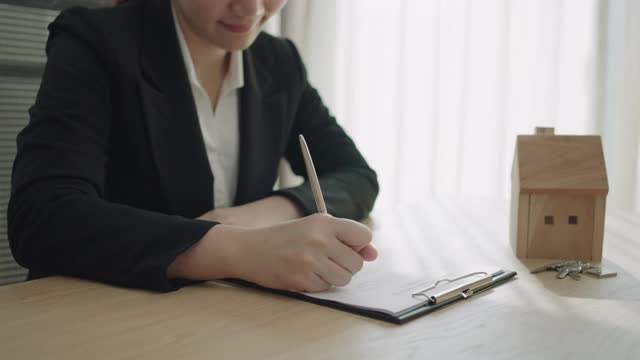 女商人正在签订购房合同，卖房子的概念就是签订合同。视频素材