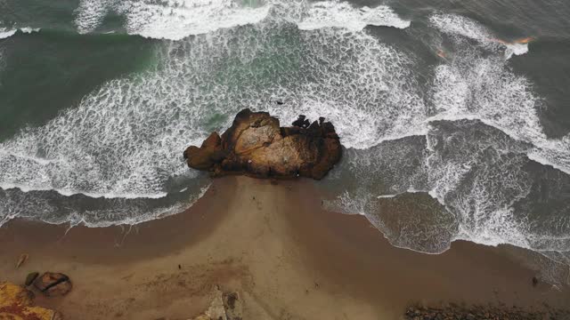 航拍海浪拍打海岸上的人在海滩上，无人机向前飞行的海岸线-旧金山，加利福尼亚视频素材