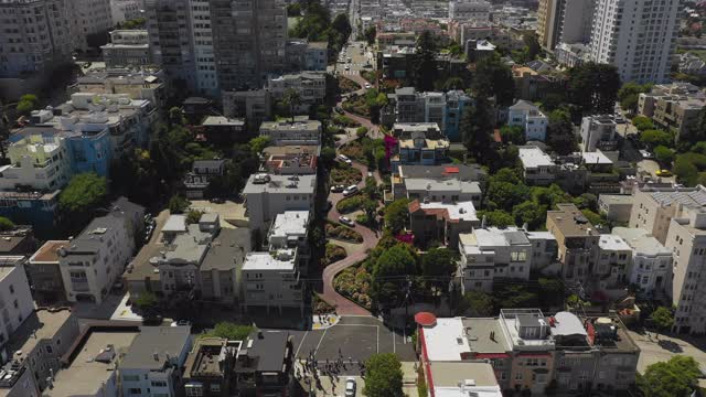 空中拍摄的汽车在曲折的街道上的建筑物，无人机下降的城市在阳光明媚的一天-旧金山，加利福尼亚视频素材