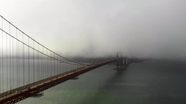 空中摇摄金门大桥与车辆在海湾下雾，无人机飞过著名的地标-旧金山，加利福尼亚视频素材