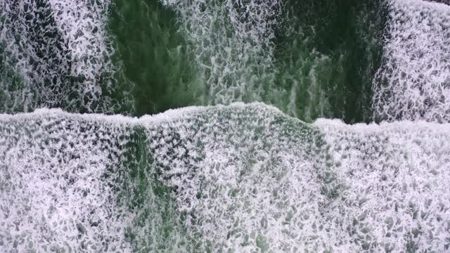 海浪在海上溅起的鸟瞰图，无人机飞过海岸线-坎农海滩，俄勒冈州视频素材