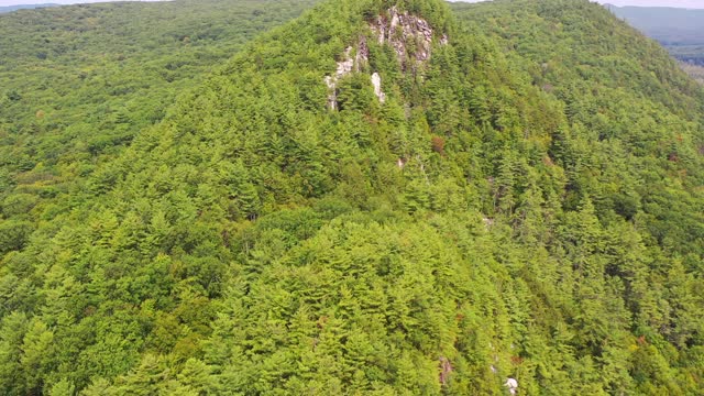 空中拍摄的岩石悬崖在森林中树木对天空，无人机向前飞行在自然郁郁葱葱的绿色景观-伯克郡，马萨诸塞州视频素材