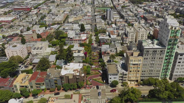 在阳光明媚的日子里，空中倾斜拍摄在城市建筑中街道上的车辆，无人机在住宅建筑上空向前飞行——旧金山，加利福尼亚视频素材