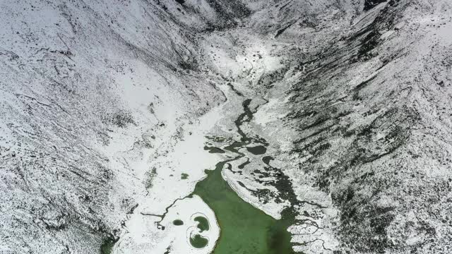 一个湖隐藏在雪山峡谷里视频素材