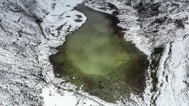 一个湖隐藏在雪山峡谷里视频素材