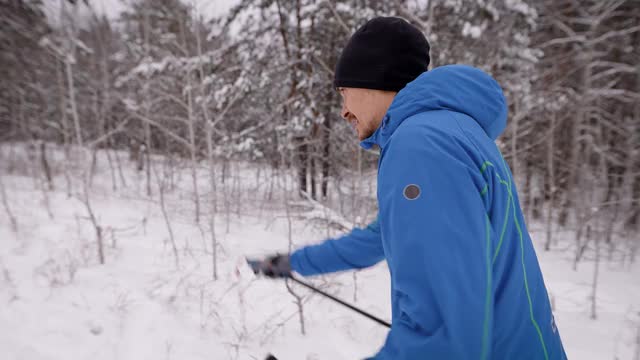 体育生活方式。一个男人在冬季森林里越野滑雪。准备视频素材