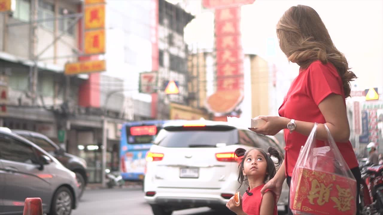 亚洲华人家庭在中国街头市场购物庆祝中国新年。视频下载