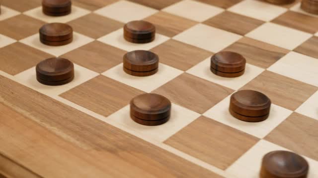 黑色的跳棋和黑色的象棋数字在一个棋盘上。旋转。关闭视图视频素材