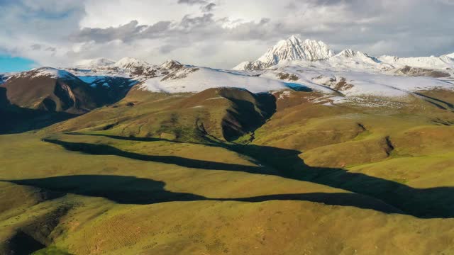 连绵不断的高山草甸和高耸的雅拉雪山，犹如一对恋人视频素材