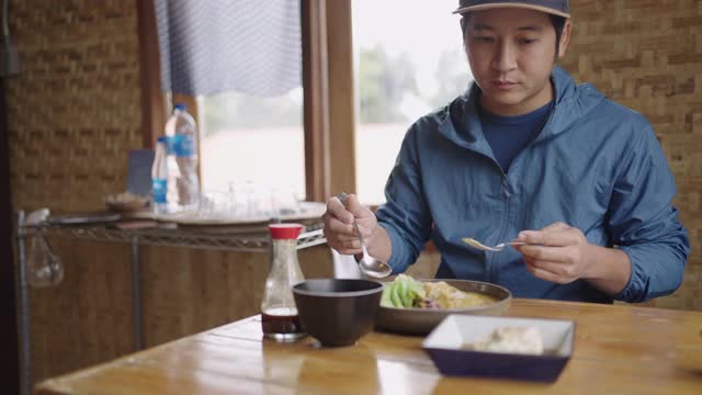 饥饿的亚洲男子喜欢吃豆腐饭。凉豆腐配菜。视频素材