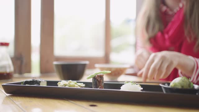 年轻的白人妇女在日本餐馆吃豆腐套餐。视频素材