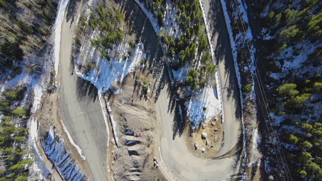 鸟瞰图(飞越)科罗拉多州的山区森林和道路在冬季。视频素材