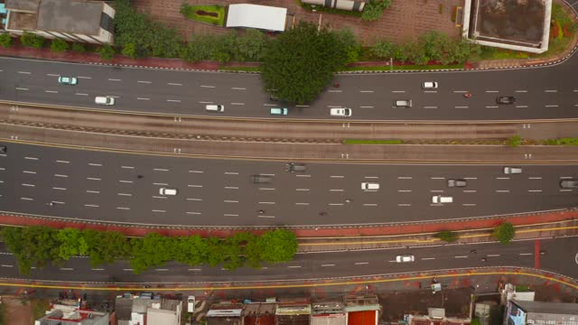 在亚洲的一条多车道高速公路上，从上到下的空中卡车视图跟随汽车和摩托车视频素材