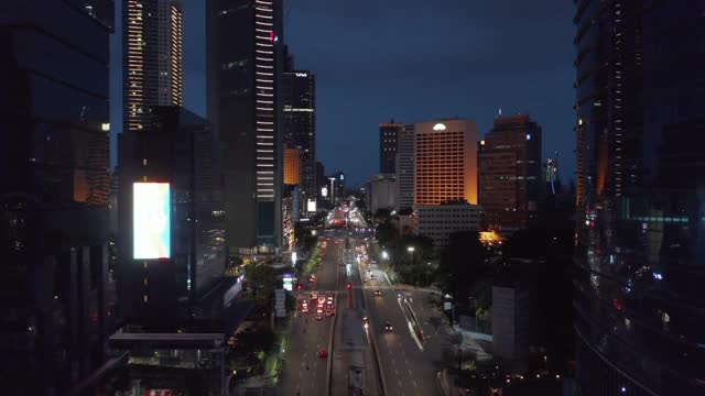 低飞的空中移动摄影车拍摄的汽车在繁忙的多车道的雅加达市中心的夜晚视频素材