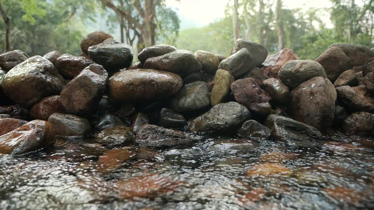 野生山河清晰的瀑布与岩石和水花。淡水在森林中流淌。慢动作特写。视频素材