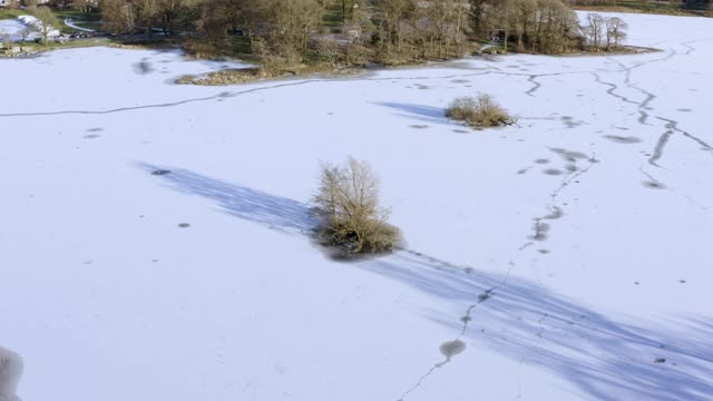 这是一个苏格兰小湖上覆盖着一层雪的高角度鸟瞰视频素材