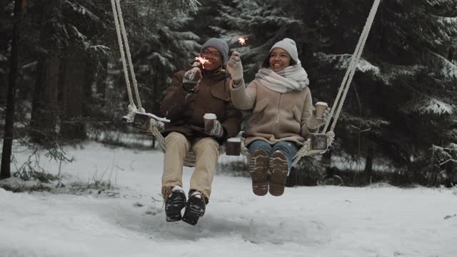 年轻的男人和女人在公园里荡秋千视频素材