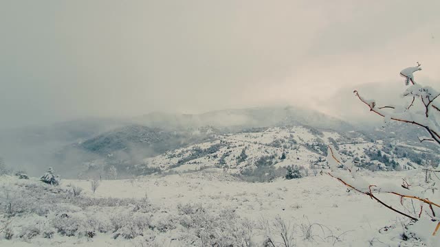 雪山在雾中。白雪覆盖的小山背景。视频素材