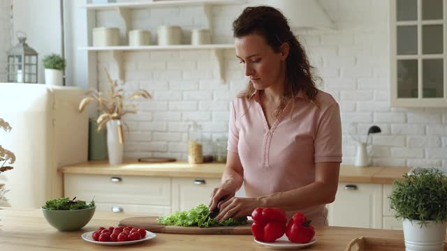 拿着刀切生菜做素食沙拉的女人视频素材