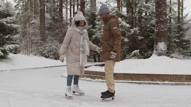 非洲男子帮助他的女朋友滑冰视频素材